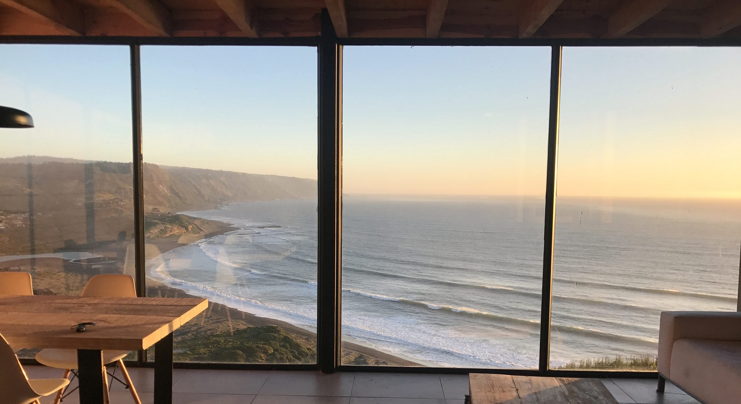 Living de una cabaña Quadro con ventanal panorámico al mar